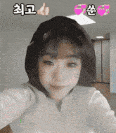 a girl wearing a cat ear hat is taking a selfie and giving a thumbs up