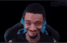 a man is making a funny face while sitting in a chair in front of a black background .