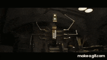a robot is standing in a dark room with a light coming out of its head .