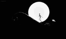 a black and white photo of a skeleton standing in front of a large white moon .