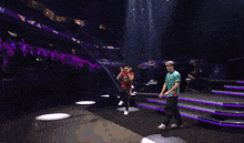a man in a red shirt that says never back down is dancing with another man in a green shirt