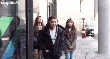 a group of girls are standing in front of a building that says dispatch on the top