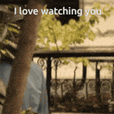 a person standing on a balcony with the words " i love watching you " written on the bottom