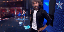 a man with a surprised look on his face stands on a stage in front of a star