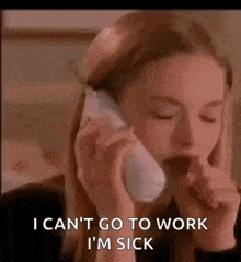 a woman is talking on a cell phone while coughing .