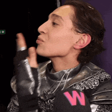 a man wearing a knight 's armor has a w on his shoulder