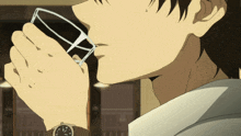 a man wearing a watch is drinking a glass