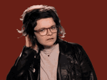 a woman wearing glasses and a ring giving the middle finger