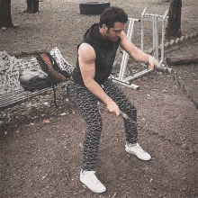 a man in a black tank top is holding a rope in his hands .