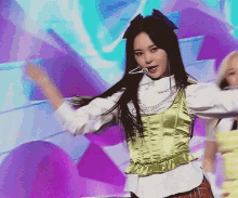 a woman with long black hair is wearing a green corset and a white shirt