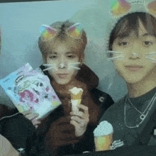 a man wearing a cat hat is holding an ice cream cone in his hand