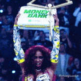 a woman is holding up a box that says money bank on it