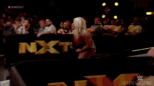 wrestlers in a wrestling ring with a sign that says nxt on it