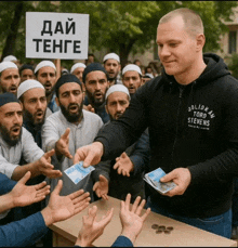 a man wearing a stevens sweatshirt is giving money to a group of people