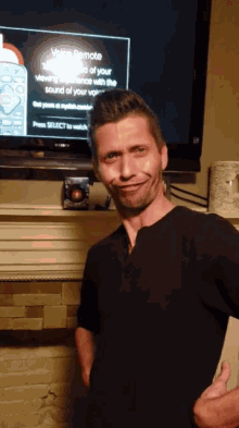 a man is standing in front of a television screen that says voice remote