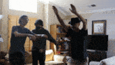 a man wearing a black hat is dancing with two other men