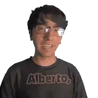 a man wearing glasses and a black shirt with the name alberto on it