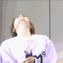 a person wearing a purple shirt with a m on it