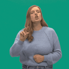 a woman in a blue sweater making a funny face