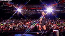 a wrestler is walking out of a ring in front of a crowd during a wrestling match .