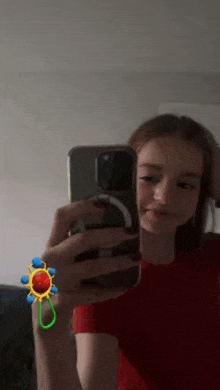 a young girl is taking a selfie with her phone in front of a mirror .