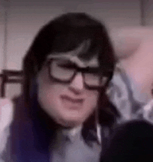 a close up of a person wearing glasses making a face .