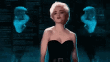 a woman in a black strapless dress is standing in front of a blurred image of a man .