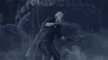a man in a trench coat is holding a gun in the dark .