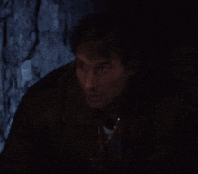 a man in a dark room is looking at the camera