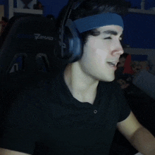 a young man wearing headphones and a headband with the word sport on it
