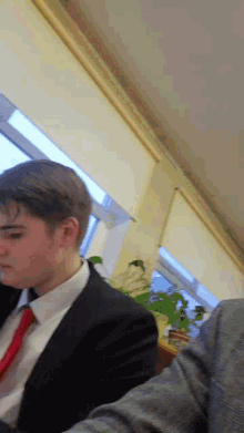 a man in a suit and tie sits in a room