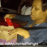 a woman is sitting in the back seat of a car holding a mcdonald 's bag .