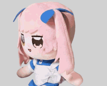 a stuffed doll with pink hair and blue bows has the letters a & a written on it
