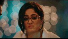 a woman wearing glasses and a white lab coat