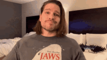 a man wearing a jaws t-shirt looks at the camera