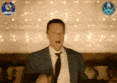 a man in a suit and tie is dancing in front of a sign that says moutal