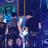 two men are standing on a stage in front of a sign that says r.