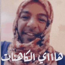 a woman wearing a scarf and a hijab is smiling