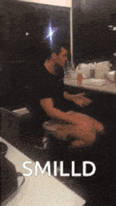 a man sitting on a toilet with the word smild on the bottom right
