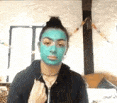 a woman is wearing a blue mask on her face and looking at the camera .