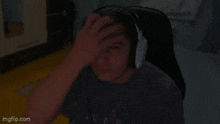 a young man wearing headphones is sitting in a chair .