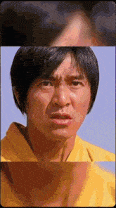 a close up of a man 's face in a yellow shirt