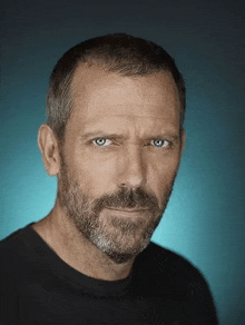 a man with a beard and blue eyes is looking at the camera with a blue background .