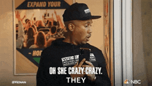 a man is holding a cell phone and says oh she crazy crazy they