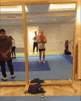 a man in a nike shirt stands in front of a large mirror