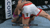 a man in a venum shorts is wrestling another man in a cage