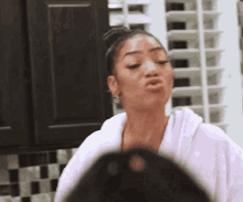 a woman is making a funny face in front of a mirror .