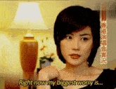 a woman in a black dress is standing in front of a lamp and says `` right now my biggest worry is ... ''