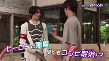 a man in a superhero costume is talking to another man in a foreign language