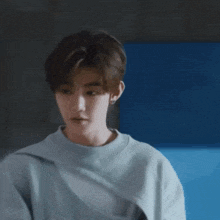 a young man wearing a grey sweater with a nike logo on it